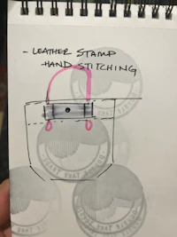 a sketch of a bag with a pink pen on it